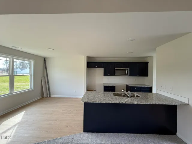 a living room with granite countertop a couch and a stove top oven