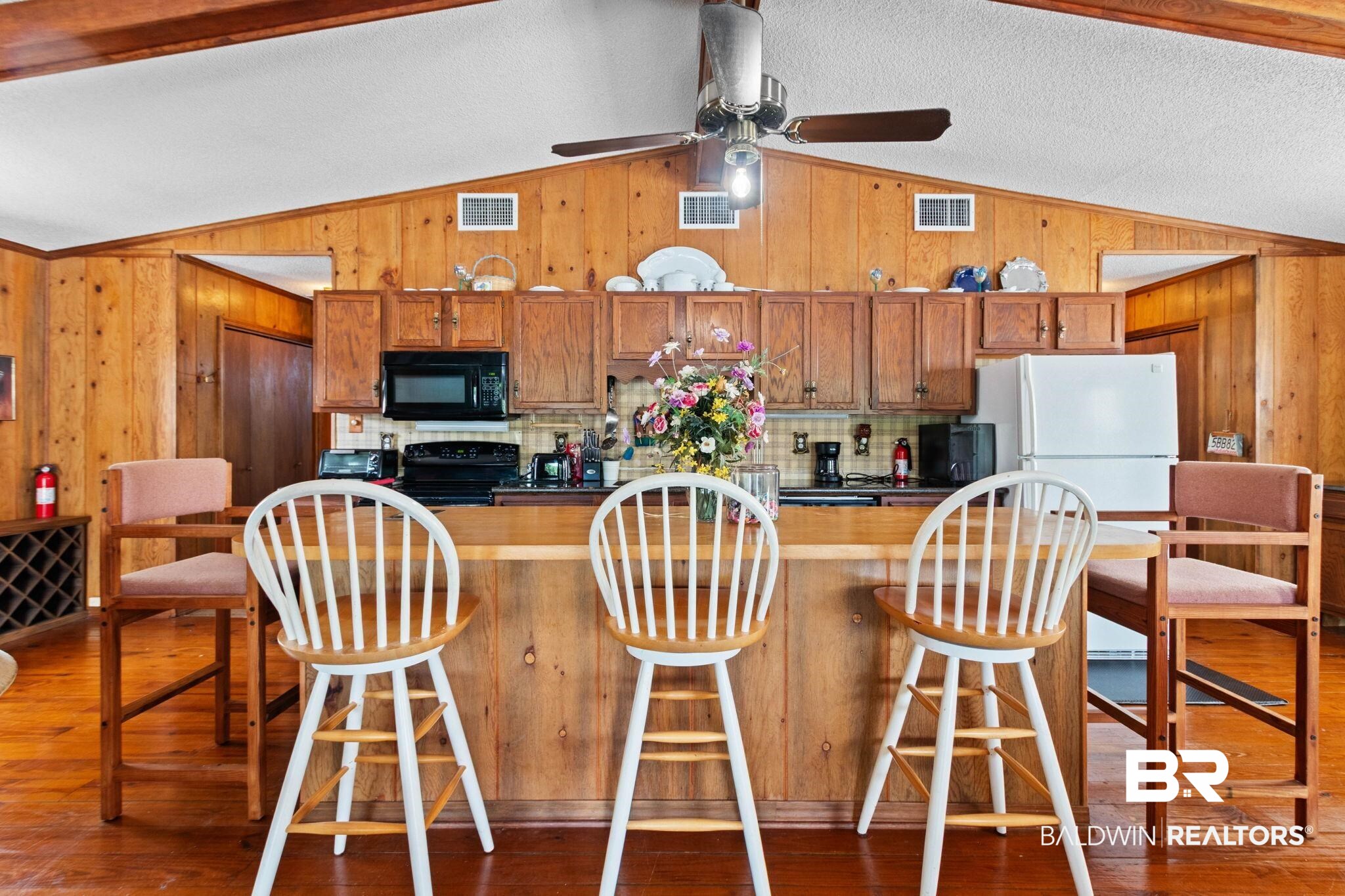 8153 Bryant's Lndg Road Stockton, AL 36579 - Photo 28 of 87 Open-concept kitchen area featuring wood-paneled walls, exposed wood beams, and a vaulted ceiling
