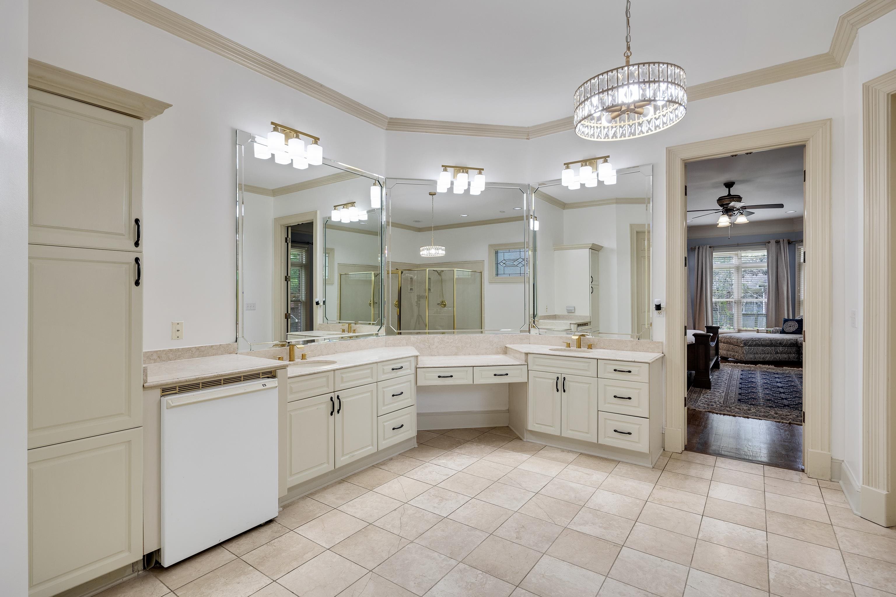 350 Bluff Ridge Cove Memphis, TN 38018 - Photo 28 of 37 Spacious bathroom featuring light-toned tile flooring, extensive vanity cabinetry with integrated sinks, and a built-in makeup vanity