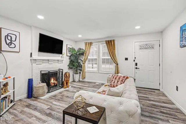 a living room with furniture a flat screen tv and a fireplace