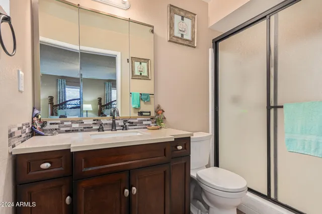a bathroom with a sink vanity mirror and toilet