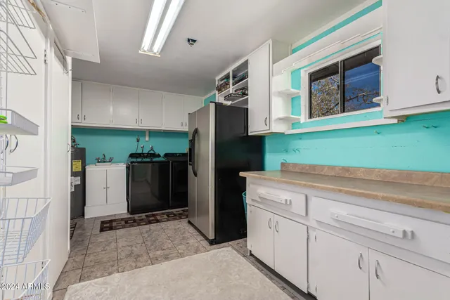a kitchen with white cabinets and refrigerator
