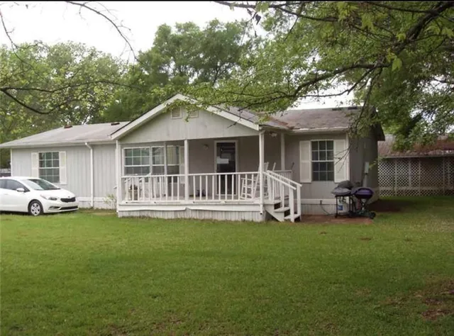 a view of a house with a yard and sitting area