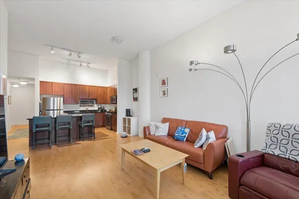 a living room with furniture and a open kitchen view