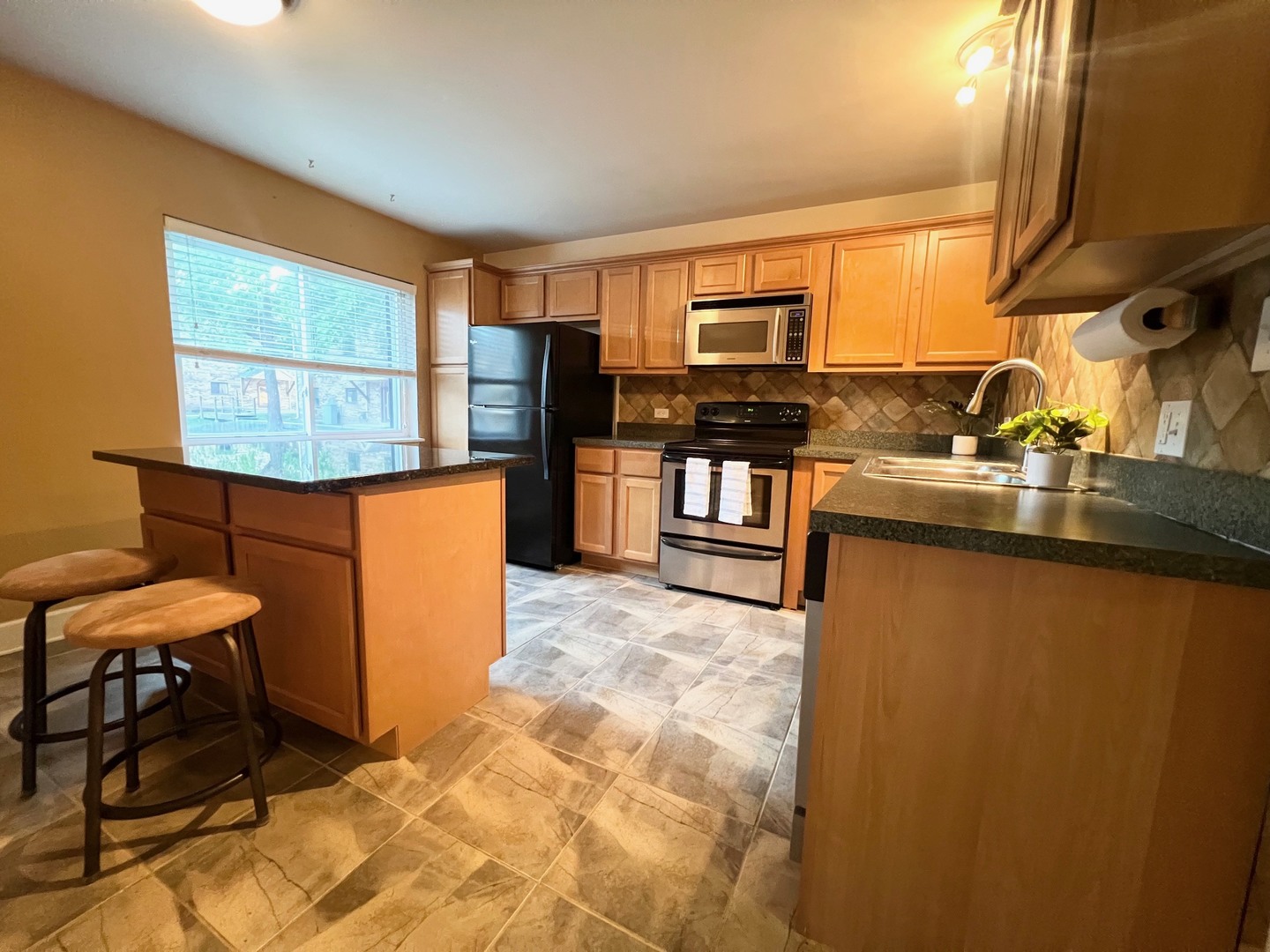 2219 Nichols Road, Unit 17A Arlington Heights, IL 60004 - Photo 8 of 19 a kitchen with stainless steel appliances granite countertop a sink counter space and a window