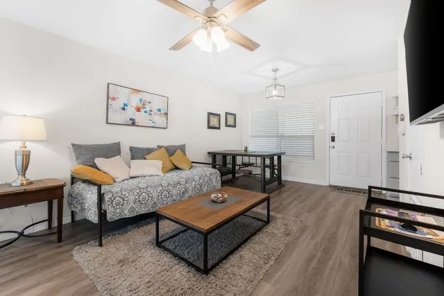 a living room with furniture a flat screen tv and a table