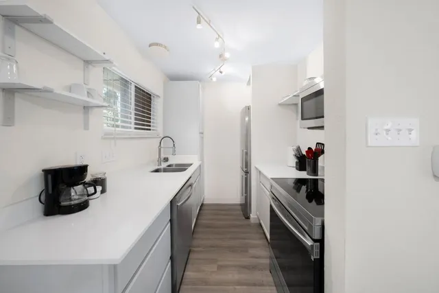 a kitchen with a sink a stove and cabinets
