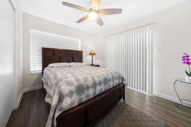 a bed sitting in a spacious bedroom next to a window