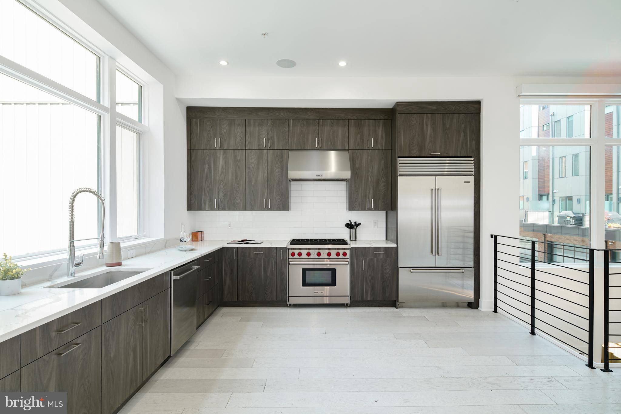 a kitchen with stainless steel appliances granite countertop a refrigerator and a sink
