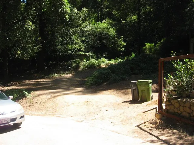 a view of a yard with wooden fence