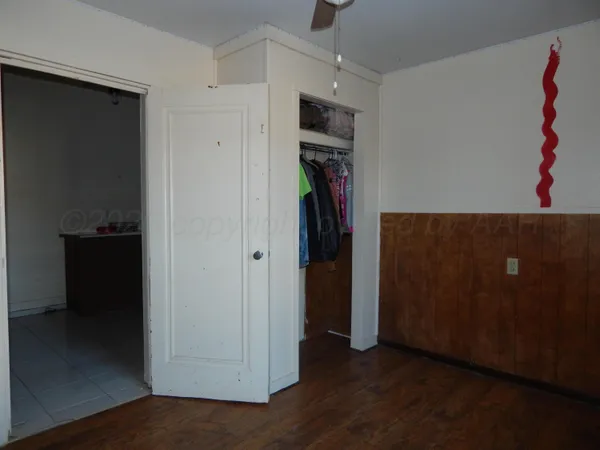 a view of a hallway with wooden floor and closet