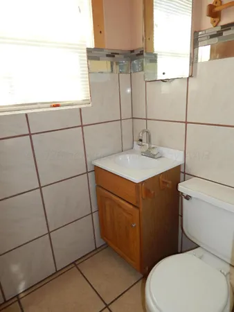 a bathroom with a sink a toilet and mirror