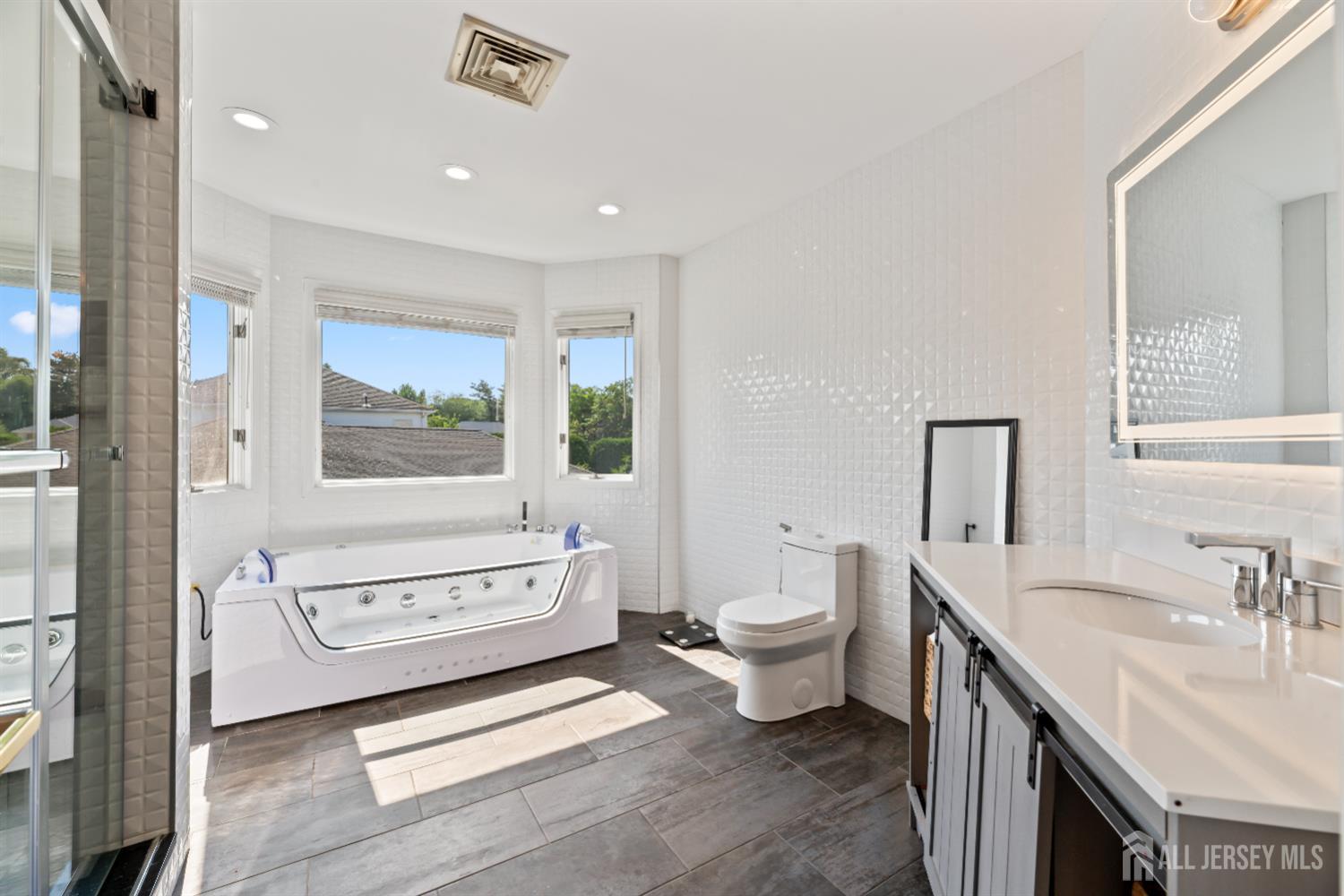 6 Allison Court Edison, NJ 08820 - Photo 20 of 53 a spacious bathroom with a double vanity sink a mirror and a bathtub