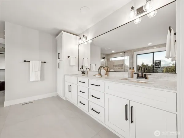 a bathroom with double vanity and a mirror