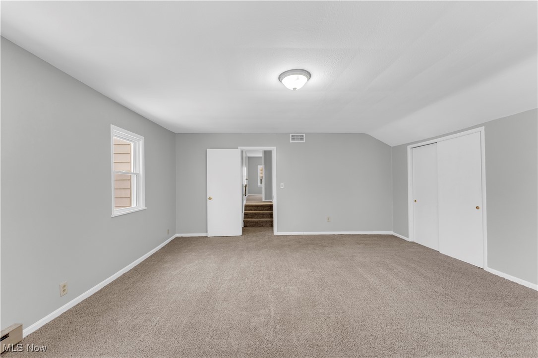 4693 Liberty Road South Euclid, OH 44121 - Photo 17 of 33 Unfurnished bedroom with carpet flooring, a closet, a baseboard heating unit, and vaulted ceiling