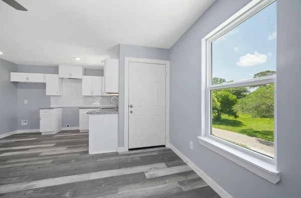 a view of a kitchen with a sink and dishwasher a refrigerator with wooden floor