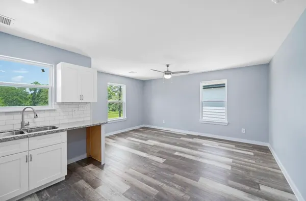 a kitchen with a sink cabinets appliances and a window
