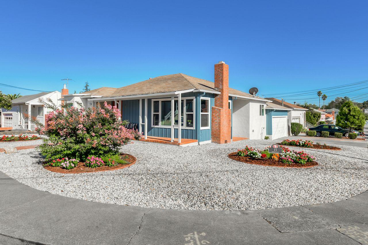 a front view of a house with a garden and plants