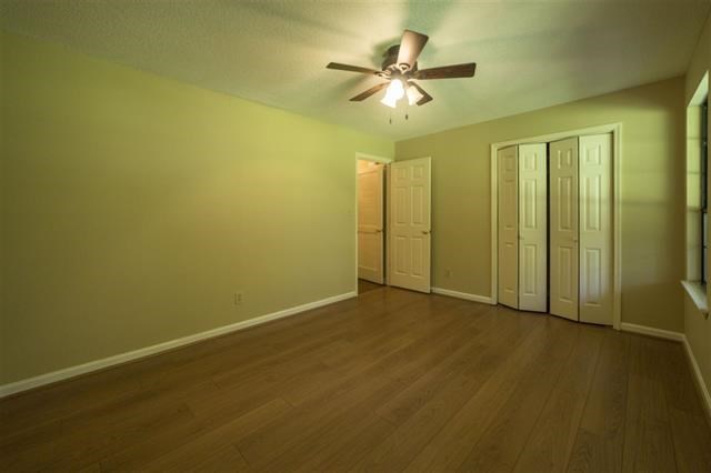 232 Lake Joy Road Perry, GA 31069 - Photo 22 of 33 an empty room with a chandelier fan and windows