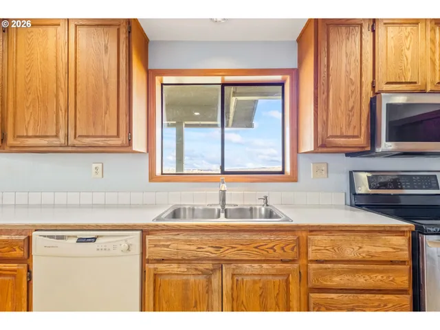 a kitchen with granite countertop wooden cabinets a sink and a window