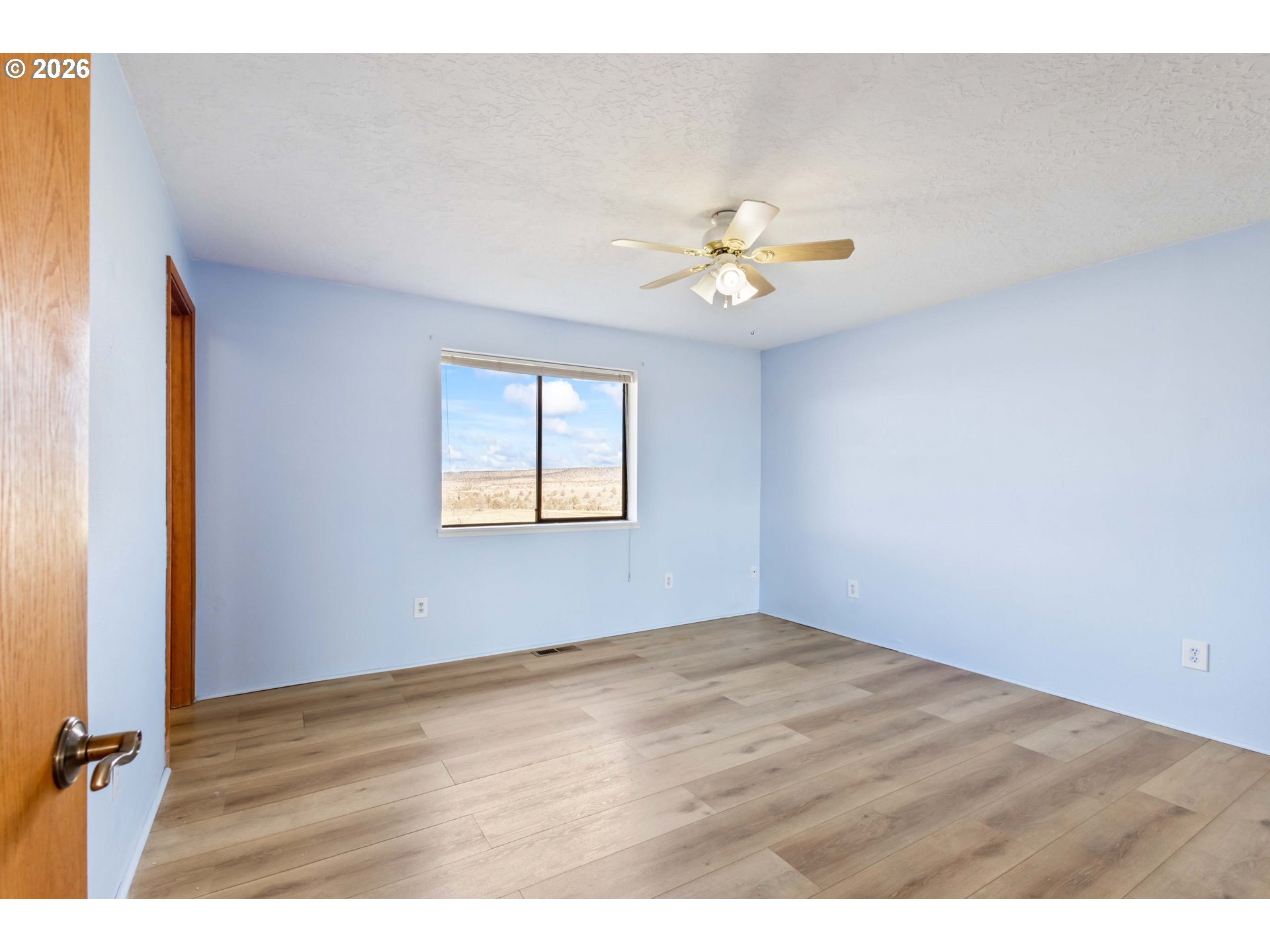 896 Southeast Dover Lane Madras, OR 97741 - Photo 14 of 44 an empty room with wooden floor and a window