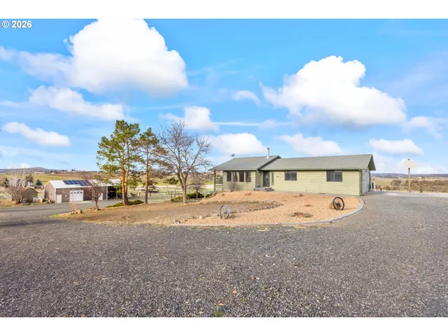 a view of a big house with a big yard and large trees