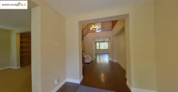 a view of a hallway with wooden floor and a living room