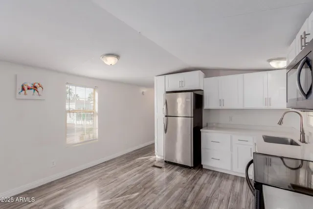 a kitchen with a refrigerator a sink and cabinets