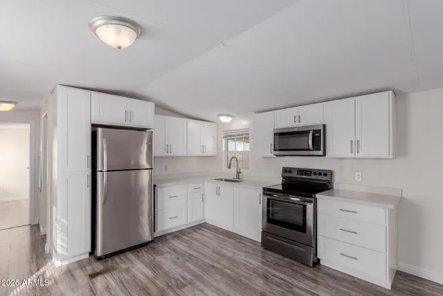a kitchen with a refrigerator stove and white cabinets