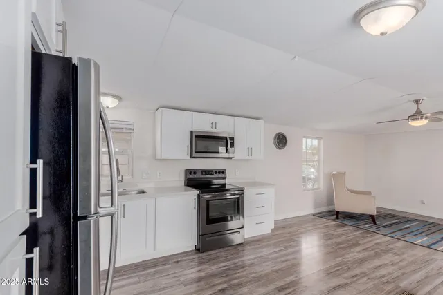 a kitchen with a refrigerator and a stove top oven
