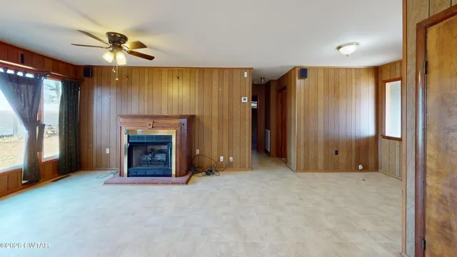 a view of an empty room with a fireplace and a window