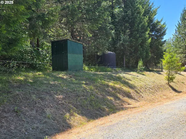 a open area with green field and trees in the background