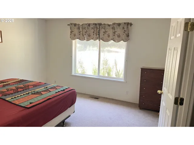 a bedroom with a bed and a painting on the wall