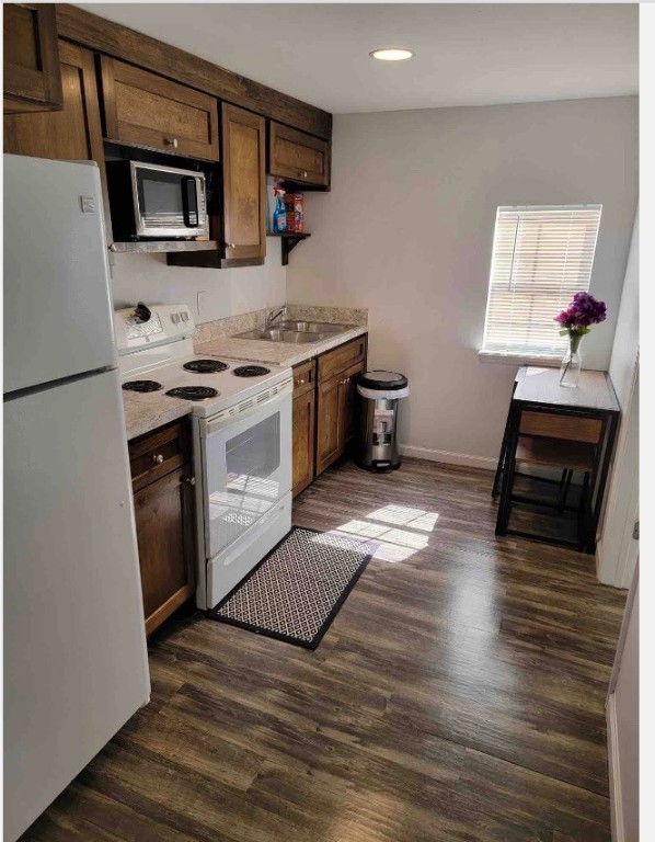 a kitchen with stainless steel appliances kitchen island granite countertop a stove a sink and a microwave