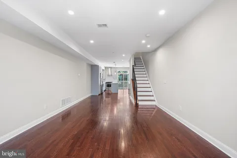 a view of a room with wooden floors and stairs