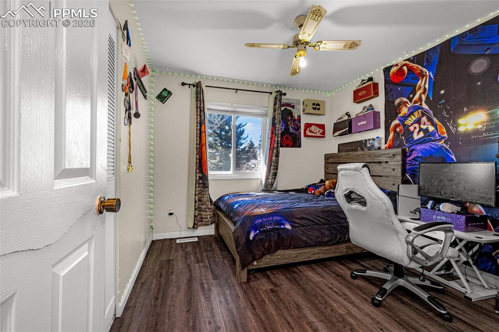 7045 Roaring Spring Terrace Fountain, CO 80817 - Photo 13 of 45 a bedroom with a bed and a chandelier