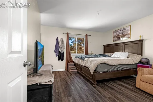a bedroom with a bed and a flat tv screen on the dresser