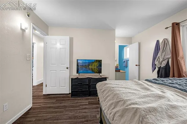 a spacious bedroom with a bed and a flat screen tv
