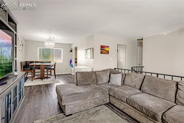 a living room with furniture and wooden floor