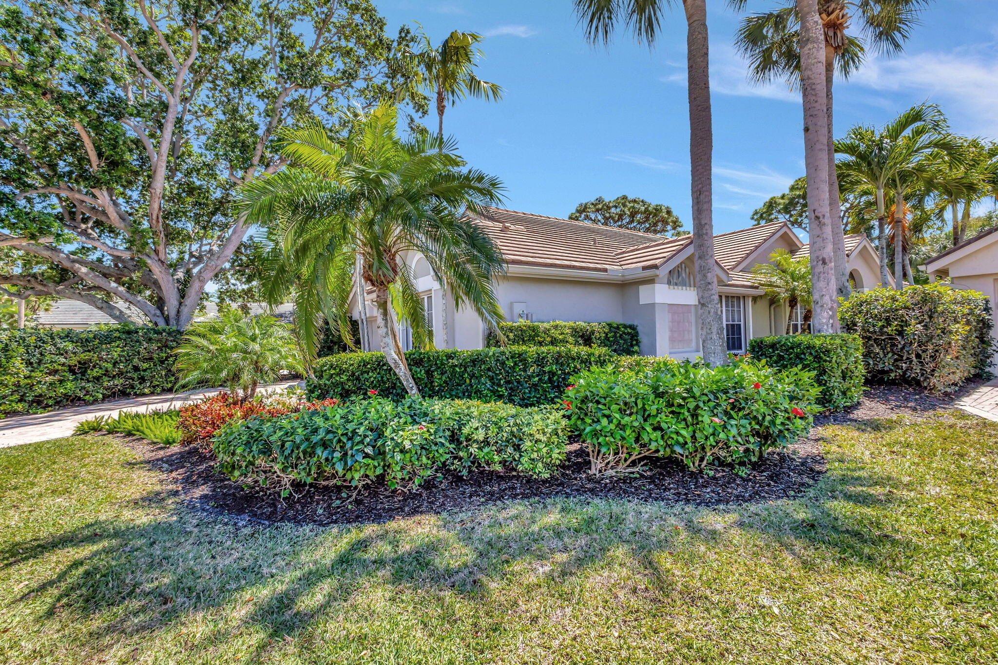 3790 Shearwater Drive Jupiter, FL 33477 - Photo 2 of 30 a front view of a house with a yard and potted plants