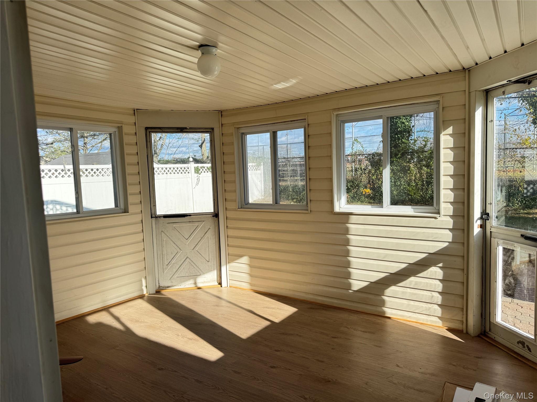129 Spring Lane Levittown, NY 11756 - Photo 16 of 18 a view of a bedroom with wooden floor and windows