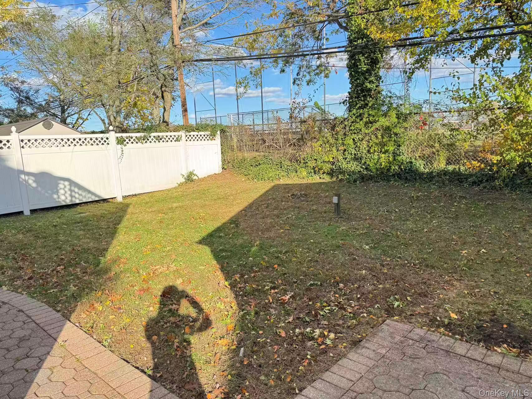 129 Spring Lane Levittown, NY 11756 - Photo 18 of 18 a view of a yard with a wooden fence