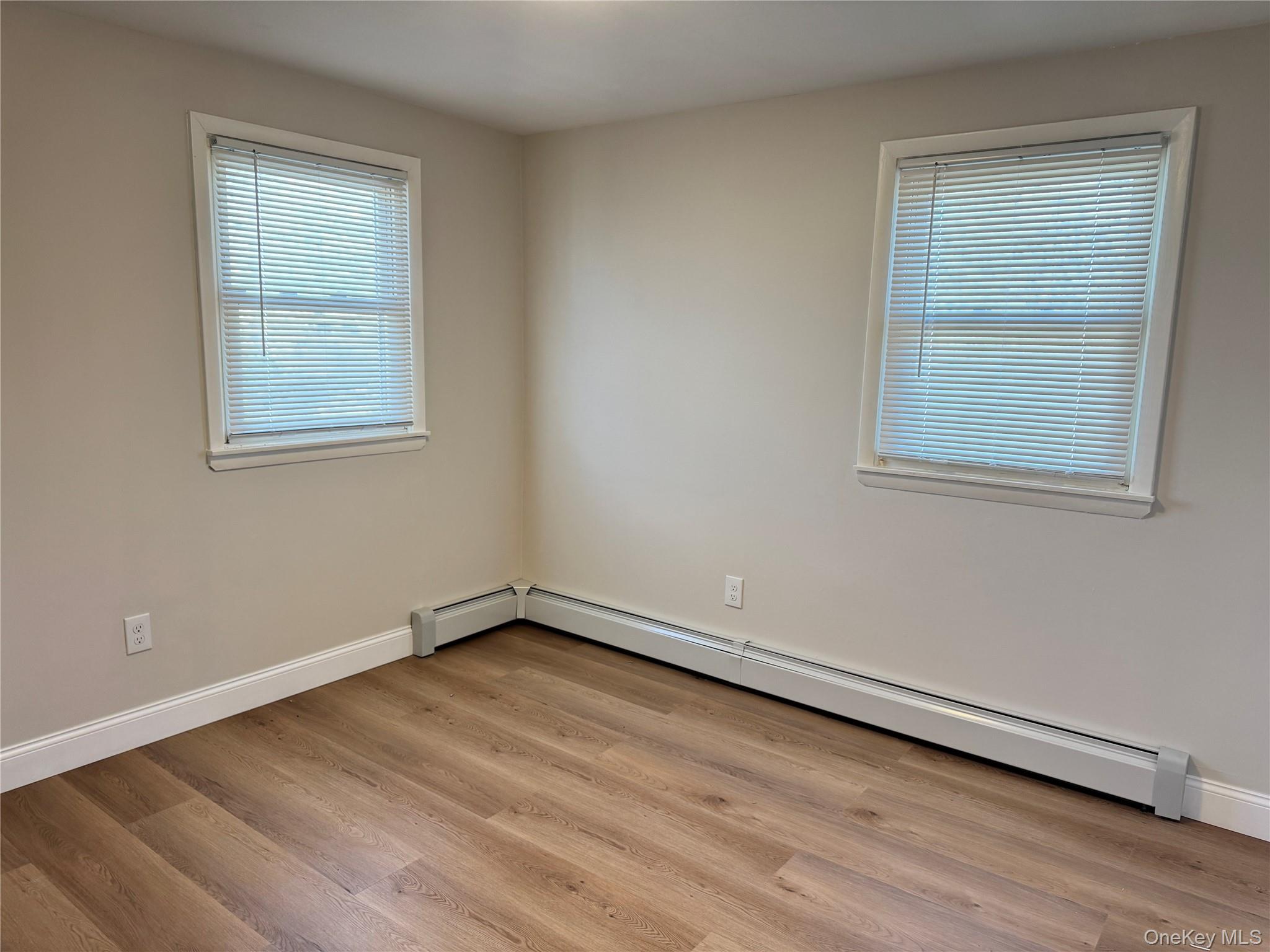 129 Spring Lane Levittown, NY 11756 - Photo 7 of 18 a view of an empty room with wooden floor and a window