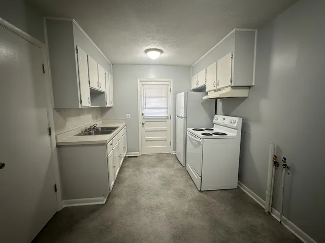 a kitchen with white cabinets and white appliances
