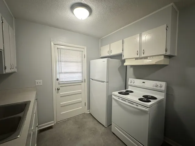a view of kitchen and refrigerator