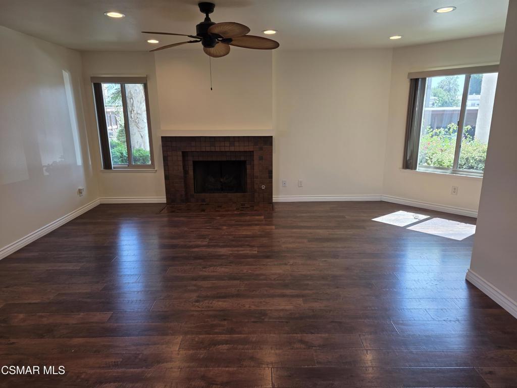 1778 Sinaloa Road, Unit 193 Simi Valley, CA 93065 - Photo 5 of 15 an empty room with wooden floor fireplace and windows