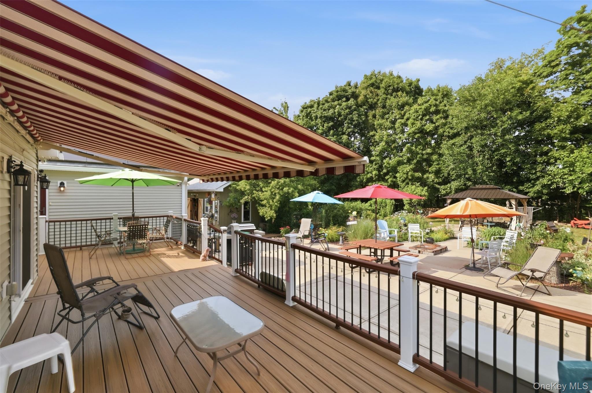 1 Hiko Place Fishkill, NY 12524 - Photo 34 of 41 Expansive rear deck featuring a retractable striped awning, composite wood-finish decking, and black metal railings