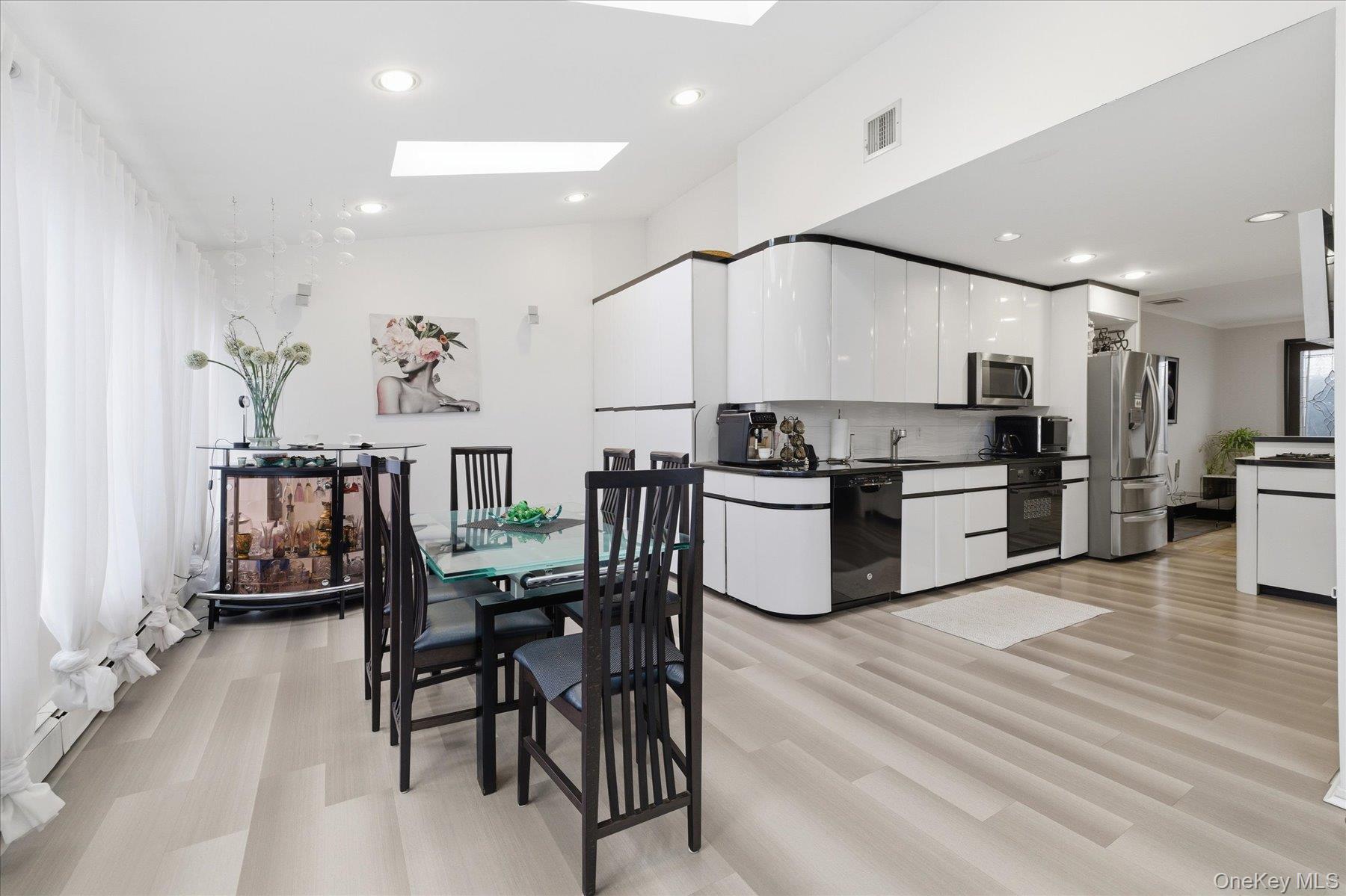 34 Reyam Road Lynbrook, NY 11563 - Photo 13 of 38 a kitchen with stainless steel appliances kitchen island granite countertop a table chairs refrigerator and microwave