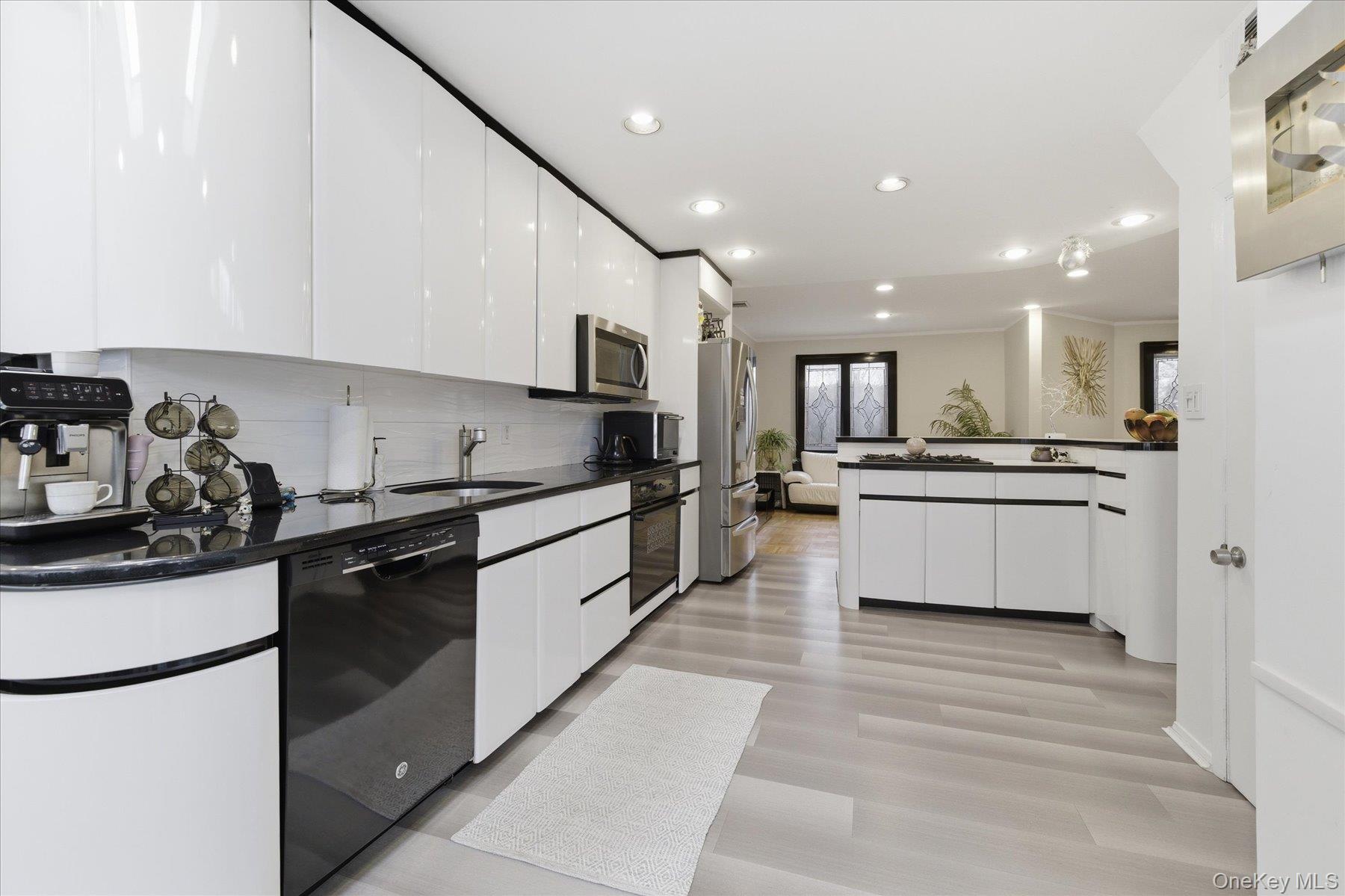 34 Reyam Road Lynbrook, NY 11563 - Photo 15 of 38 a large kitchen with stainless steel appliances kitchen island granite countertop a stove a sink a refrigerator and white cabinets