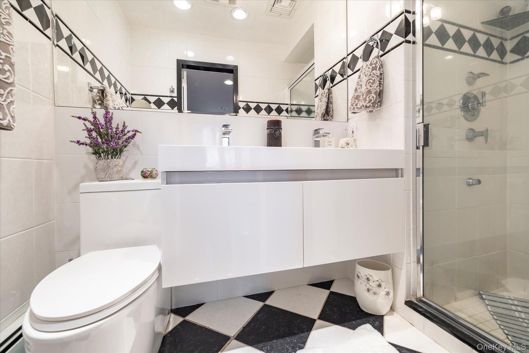 34 Reyam Road Lynbrook, NY 11563 - Photo 19 of 38 a bathroom with a sink a toilet and shower